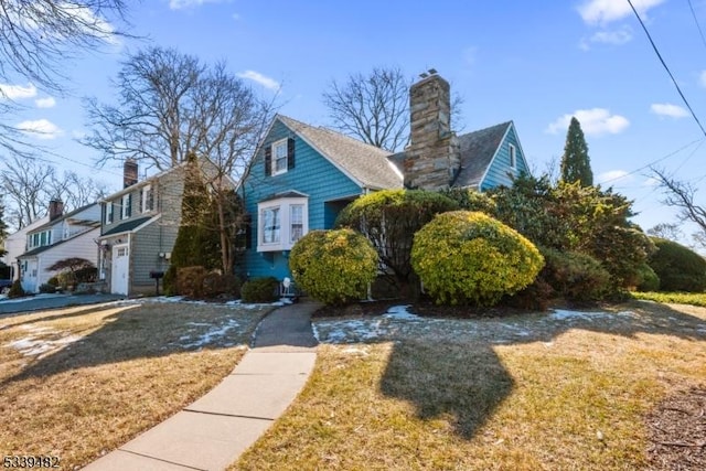 view of side of property with a chimney and a lawn