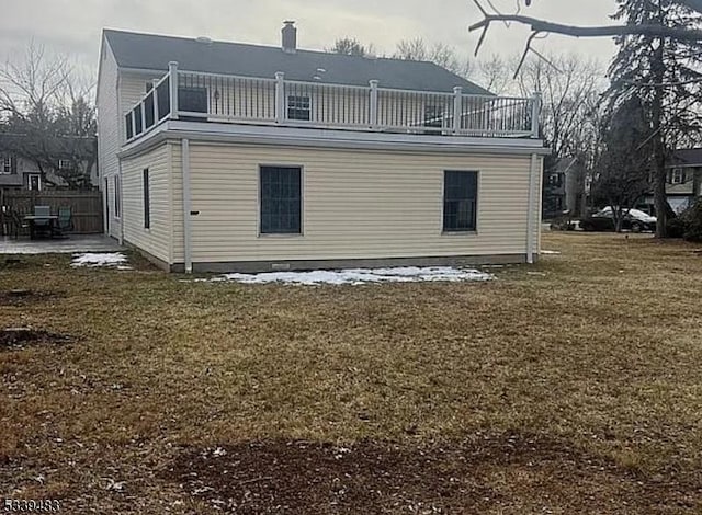 rear view of property with a patio area, a yard, and a balcony