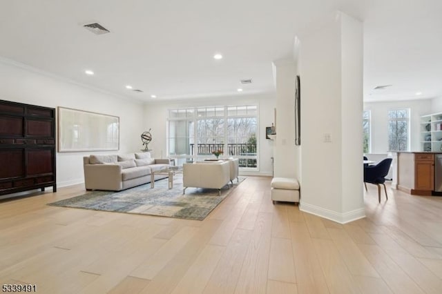 living room featuring visible vents, crown molding, baseboards, light wood-type flooring, and recessed lighting