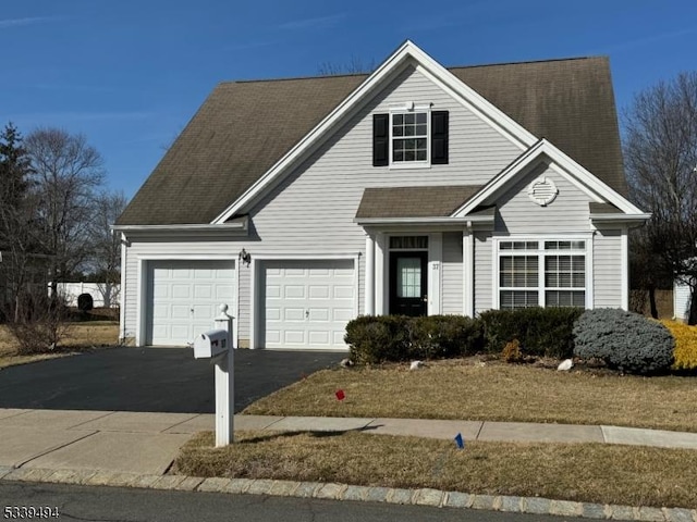 view of front of home with aphalt driveway, a shingled roof, and a garage