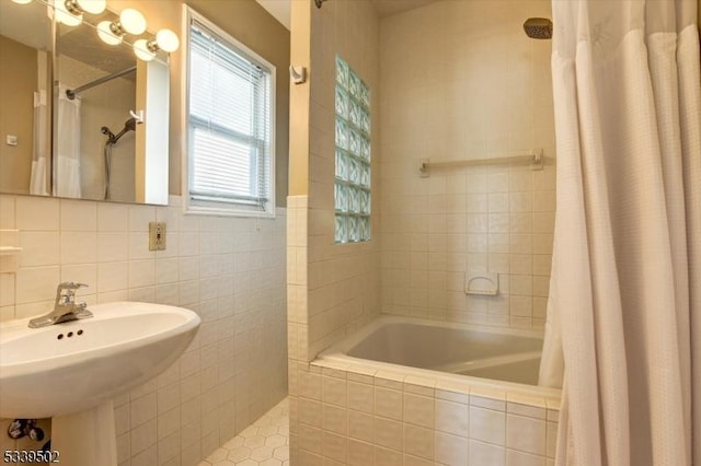 full bathroom featuring a sink and tile walls