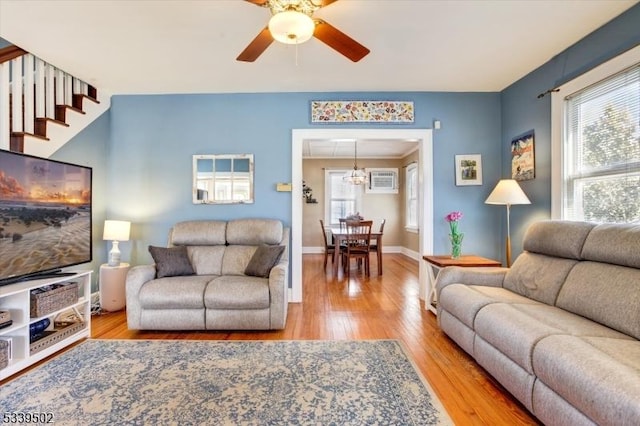 living area with wood finished floors, a ceiling fan, and baseboards