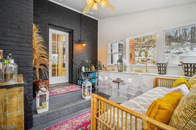 bedroom featuring brick wall and a ceiling fan