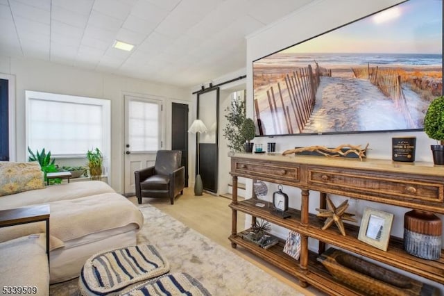 sitting room with a barn door and wood finished floors