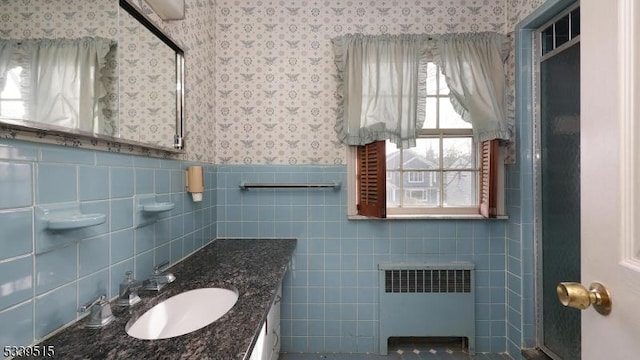 bathroom with wallpapered walls, radiator heating unit, a wainscoted wall, and vanity