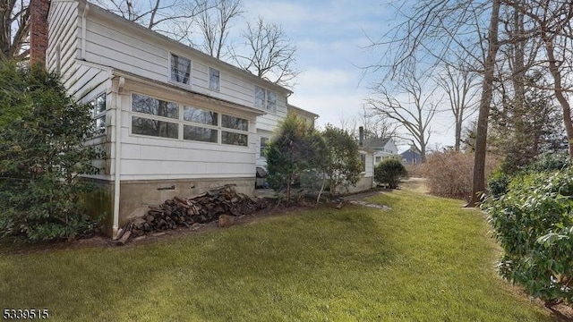 view of home's exterior with a chimney and a lawn