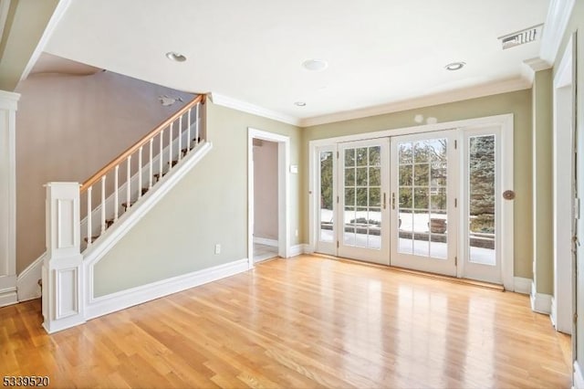 entryway featuring visible vents, stairs, french doors, ornamental molding, and light wood-type flooring