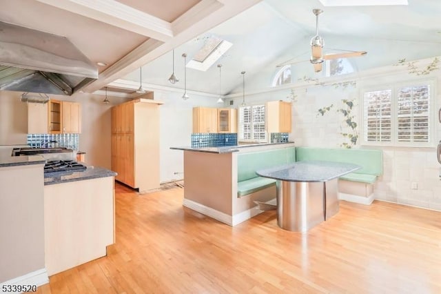 kitchen with light wood-style floors, a center island, pendant lighting, and dark countertops