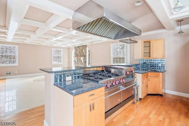 kitchen featuring range with two ovens, range hood, visible vents, glass insert cabinets, and light brown cabinets