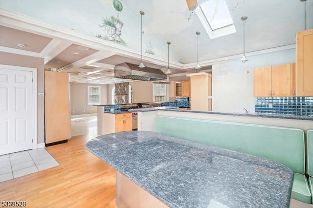 kitchen featuring light brown cabinetry, light wood finished floors, a peninsula, and pendant lighting