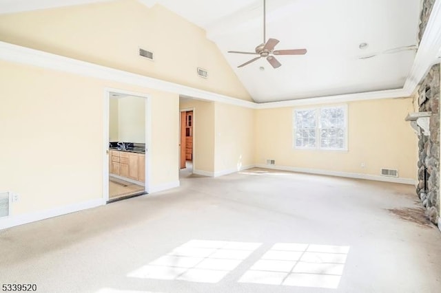 empty room with high vaulted ceiling, visible vents, and a stone fireplace