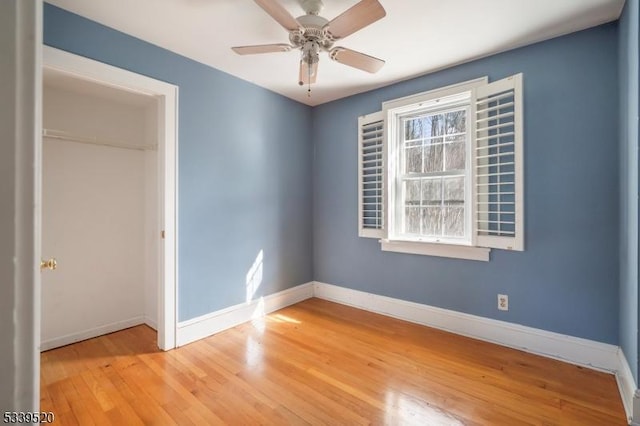 unfurnished bedroom featuring light wood-type flooring, a closet, ceiling fan, and baseboards