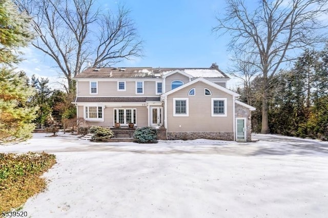 view of snow covered back of property