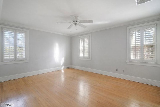 unfurnished room featuring ornamental molding, light wood-type flooring, visible vents, and baseboards