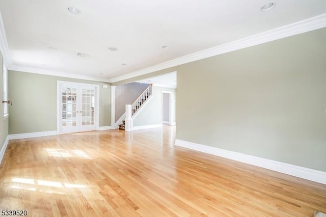 unfurnished room with light wood-style flooring, stairs, baseboards, and french doors