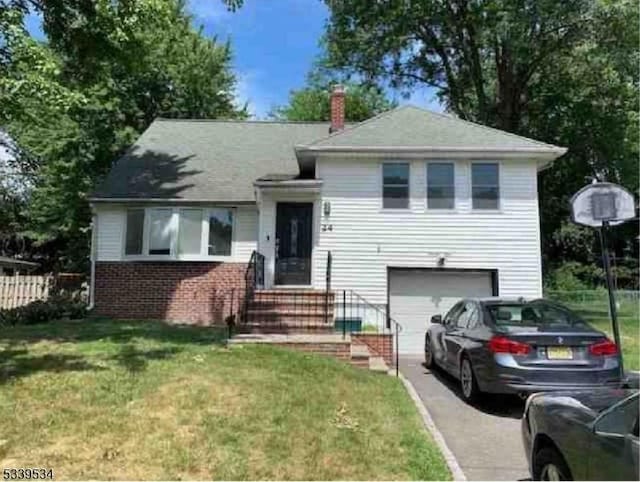 tri-level home with a garage, driveway, a chimney, a front lawn, and brick siding