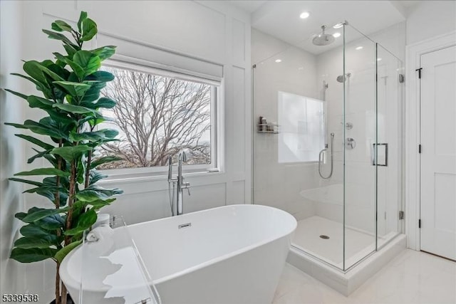 full bathroom with a stall shower, marble finish floor, and a freestanding bath