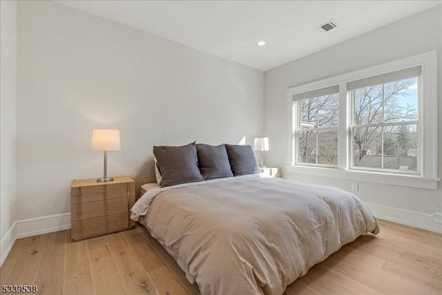 bedroom featuring light wood-type flooring, visible vents, baseboards, and recessed lighting