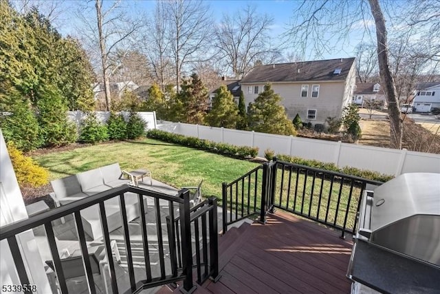 deck featuring a yard, a fenced backyard, a residential view, and a grill