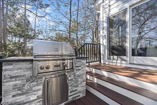 wooden deck with an outdoor kitchen and area for grilling