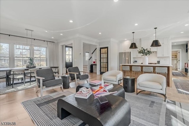 living area featuring a healthy amount of sunlight, stairway, and recessed lighting