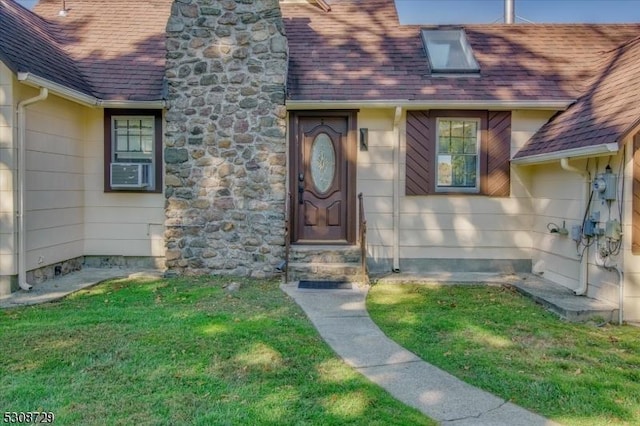 doorway to property featuring stone siding, roof with shingles, and a lawn