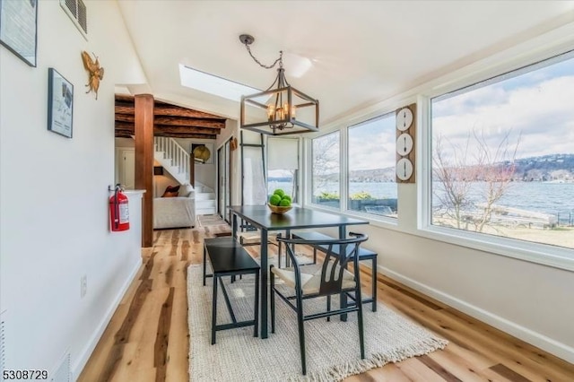 sunroom / solarium featuring a water view, visible vents, and an inviting chandelier