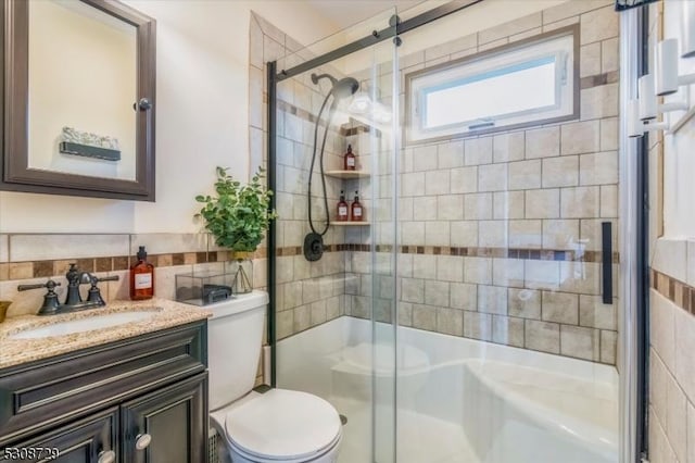 full bathroom with toilet, a shower stall, tile walls, and vanity