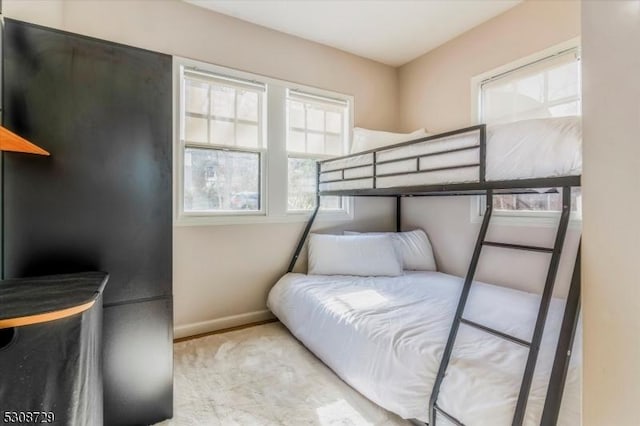 bedroom with light colored carpet and baseboards