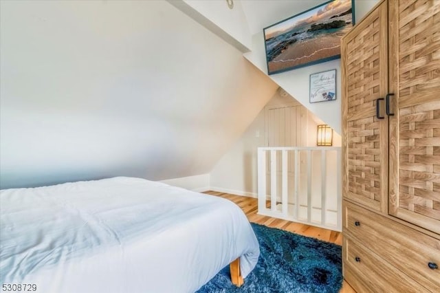 bedroom featuring vaulted ceiling and wood finished floors