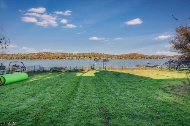 view of yard with a water view and fence