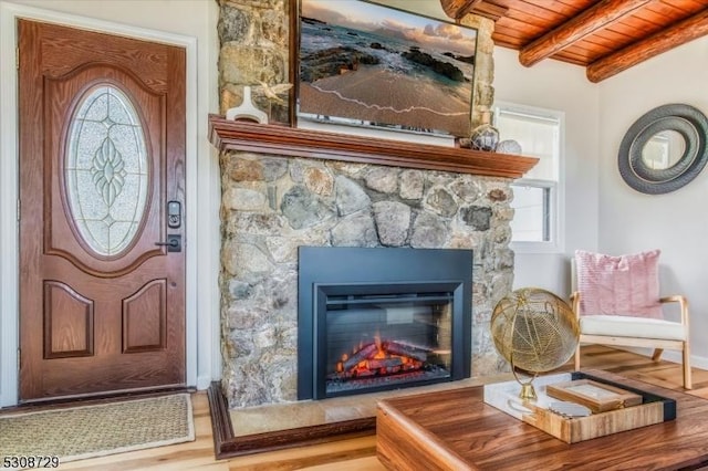 interior space with wood finished floors and a stone fireplace