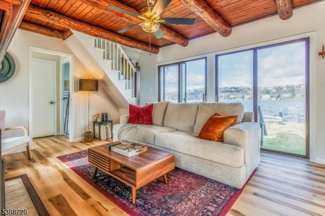 living room with stairs, light wood-type flooring, beamed ceiling, and wooden ceiling