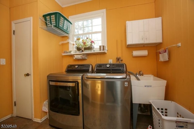 laundry area featuring a sink, laundry area, washing machine and dryer, and wooden walls