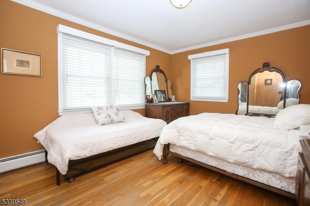 bedroom with a baseboard heating unit, ornamental molding, and wood finished floors