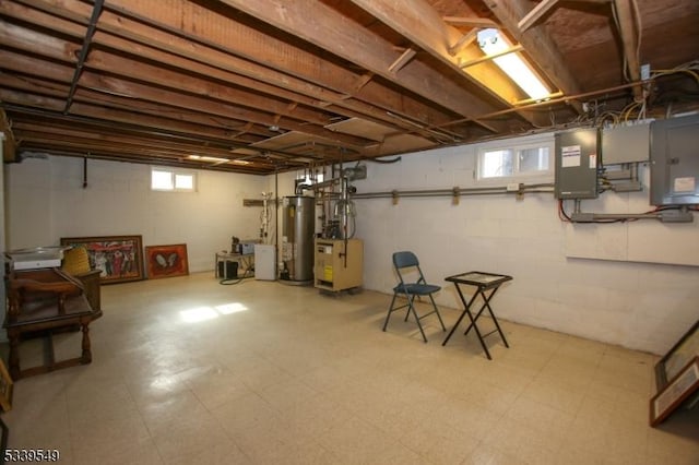 below grade area with gas water heater, electric panel, and tile patterned floors