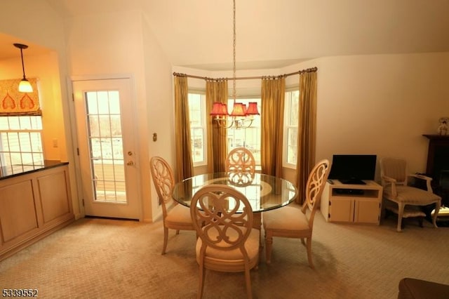 dining area with light carpet and an inviting chandelier