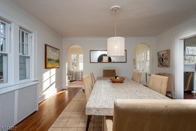 dining area with radiator, arched walkways, dark wood finished floors, and crown molding