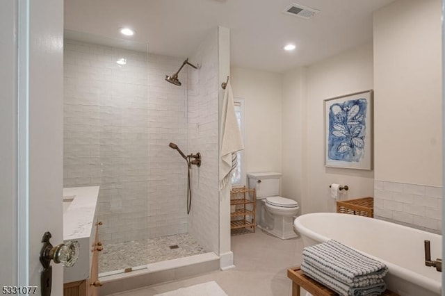 full bathroom featuring recessed lighting, visible vents, toilet, a walk in shower, and a freestanding tub