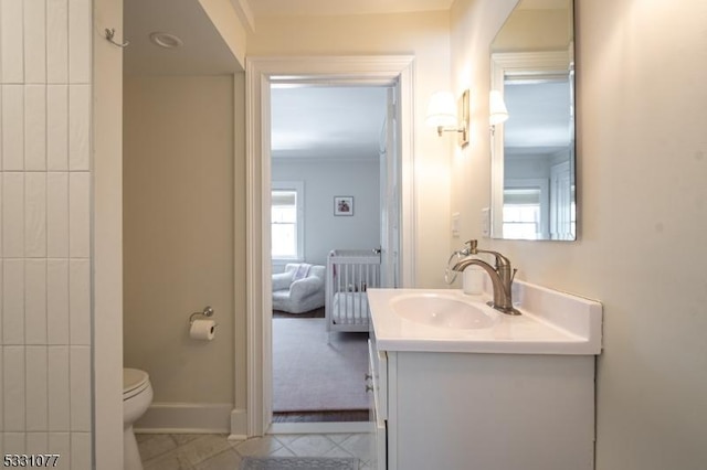 bathroom with baseboards, vanity, toilet, and tile patterned floors