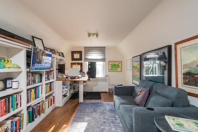 home office with vaulted ceiling, wood finished floors, and radiator