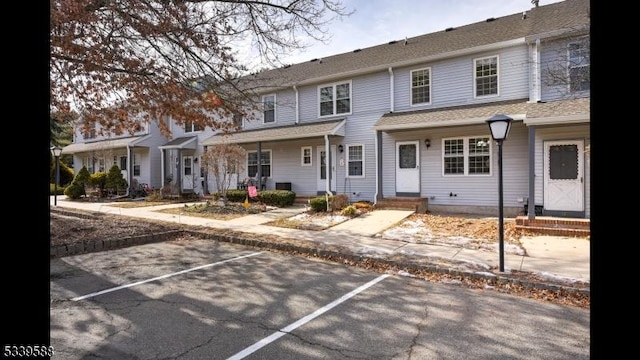 view of property featuring entry steps and uncovered parking