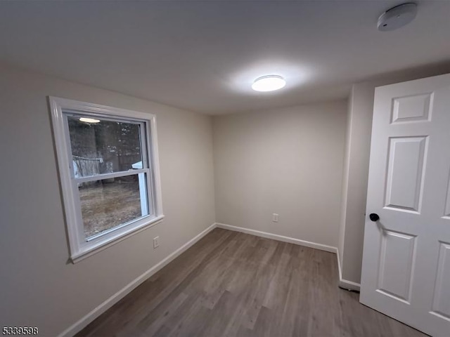 empty room featuring baseboards and wood finished floors