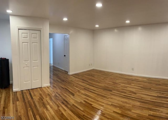 unfurnished room with baseboards, dark wood-type flooring, and recessed lighting