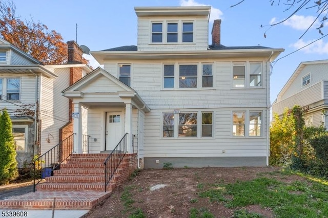 american foursquare style home featuring a chimney