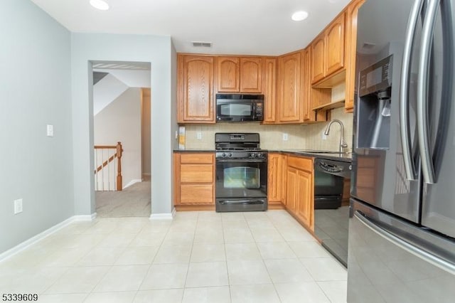 kitchen featuring tasteful backsplash, visible vents, a sink, and black appliances