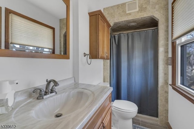 full bathroom with toilet, vanity, visible vents, and a shower with shower curtain