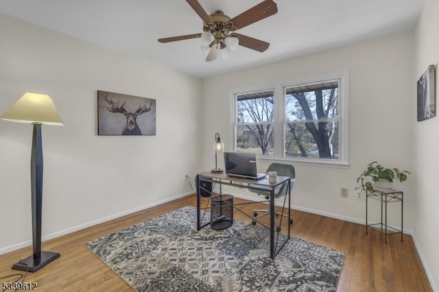 home office featuring a ceiling fan, baseboards, and wood finished floors