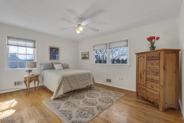 bedroom featuring light wood-type flooring, baseboards, visible vents, and a ceiling fan