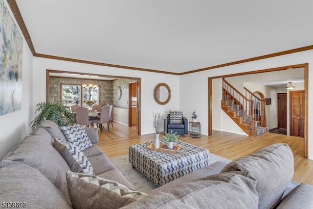 living area with stairs, ornamental molding, and wood finished floors